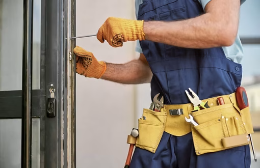Maintenance technician repairing a commercial door lock with tools as part of a preventative maintenance service