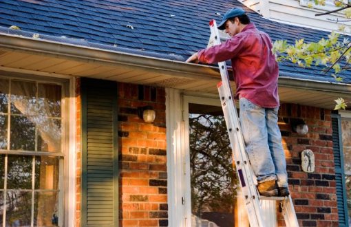 Maintenance worker repairing a commercial roof as part of a preventative property maintenance plan