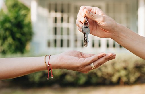 Tenant receiving keys to a new rental apartment from a property manager during move-in.