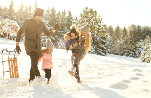 Family playing together in the snow during winter
