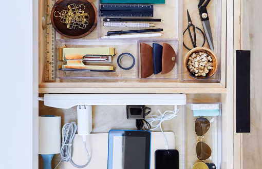 Organized apartment drawer with divided compartments neatly storing household items for efficient small-space organization.